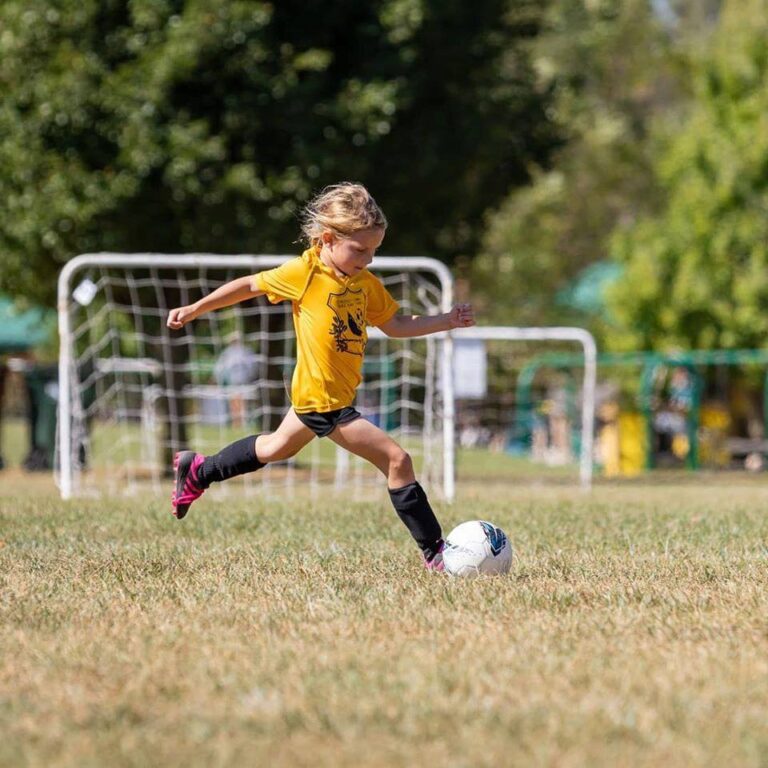 Girl kicking soccer ball